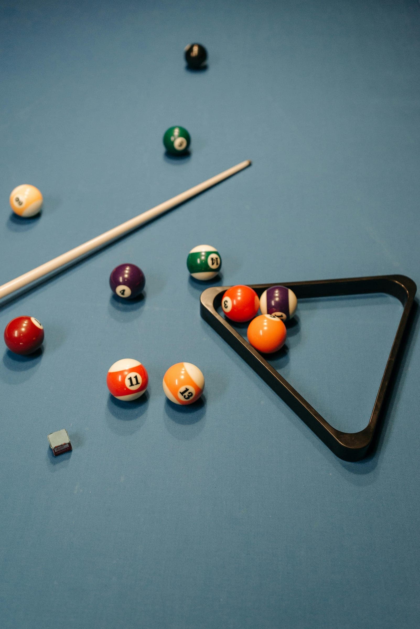 Billiard balls and a rack on blue cloth