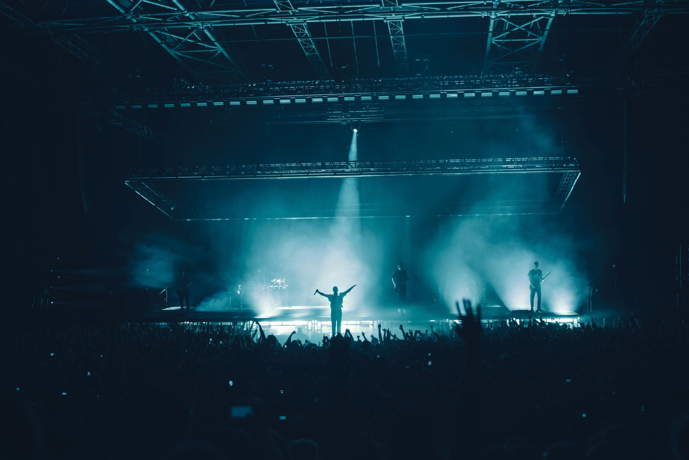 A crowd under stage lights at a concert