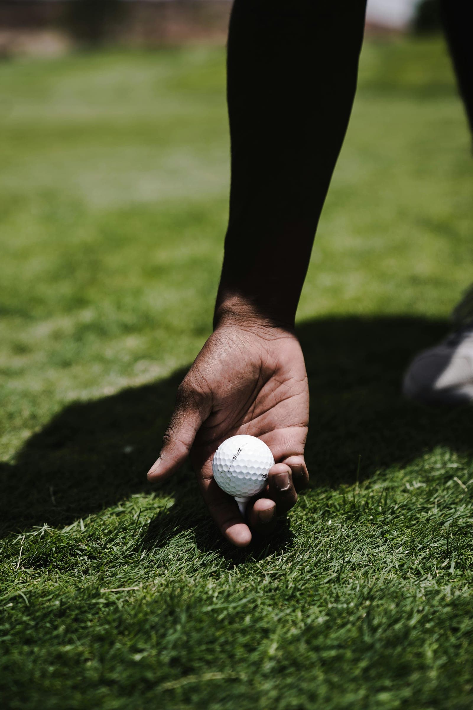 A golfer placing a ball on a tee