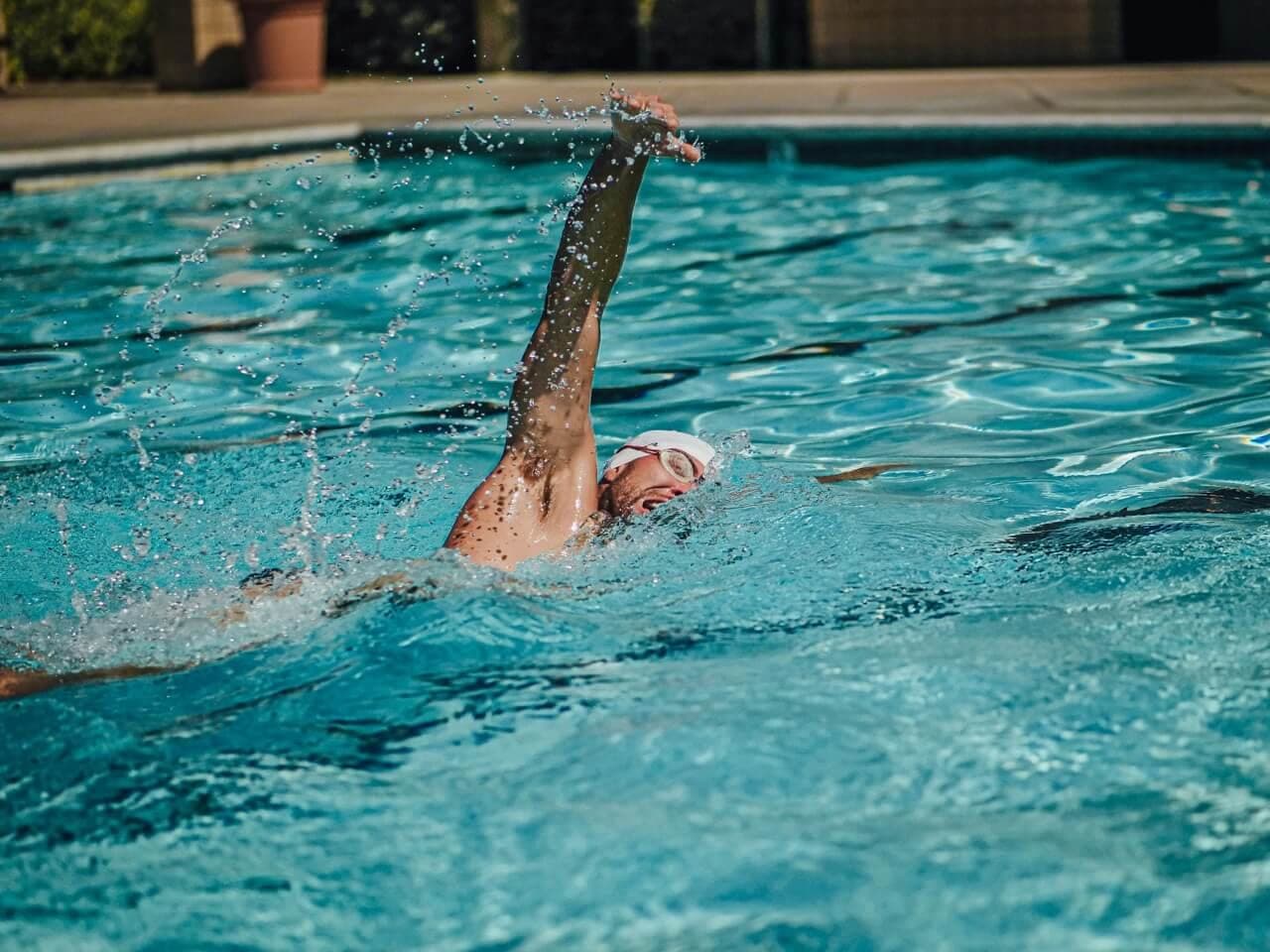A swimmer mid-stroke in a clear pool